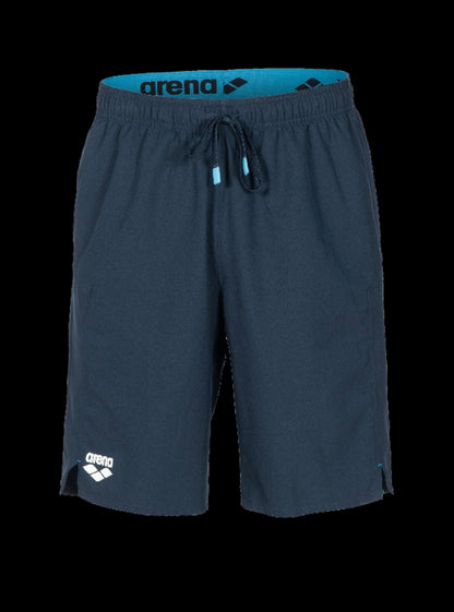 A pair of Arena athletic shorts in dark slate blue with a bright blue inner waistband and white logo details, shown against a solid black background.